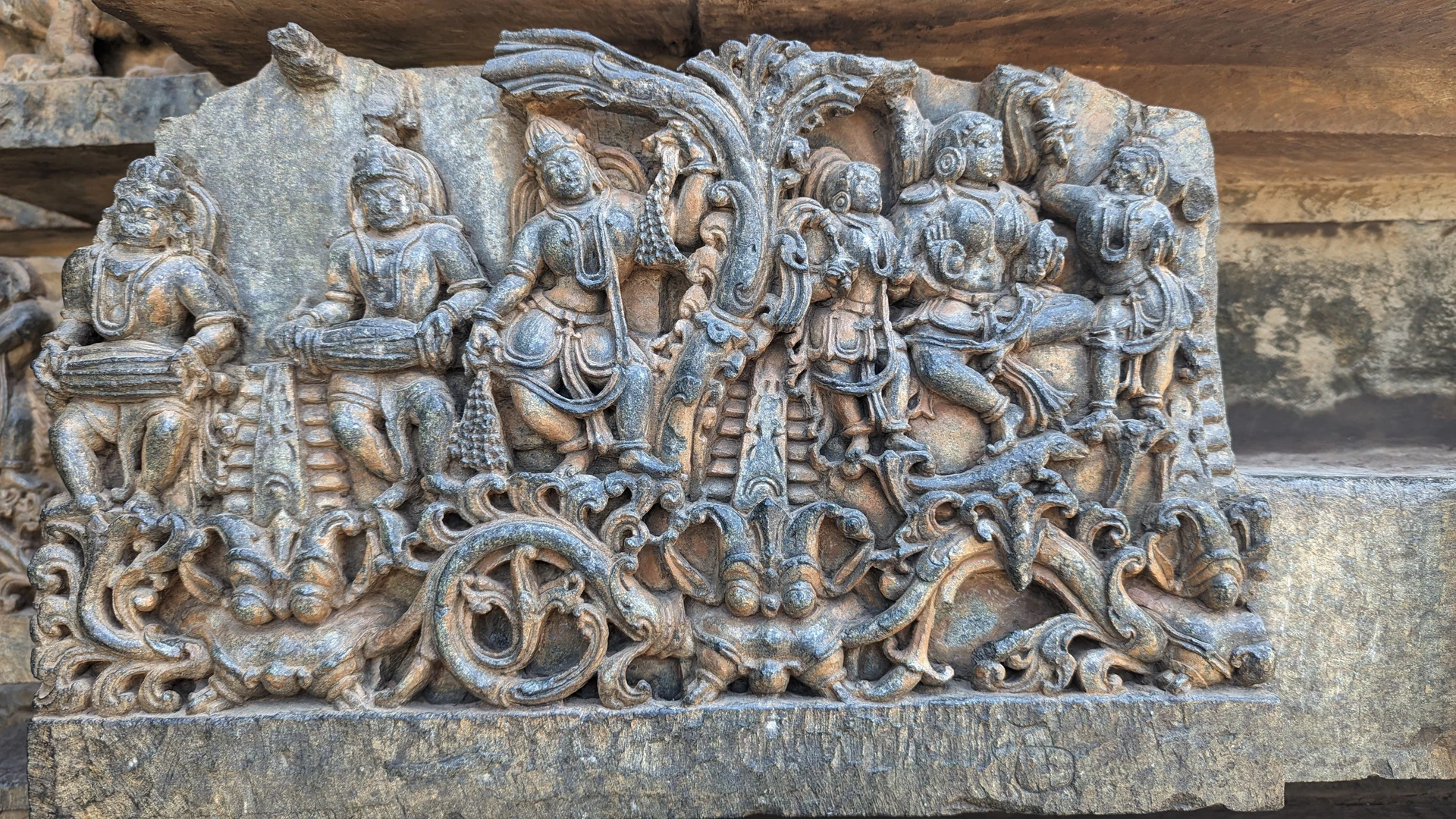 Musicians and dancers frieze at Hoysaleswara Temple — mridangam player and flutist carved in stone