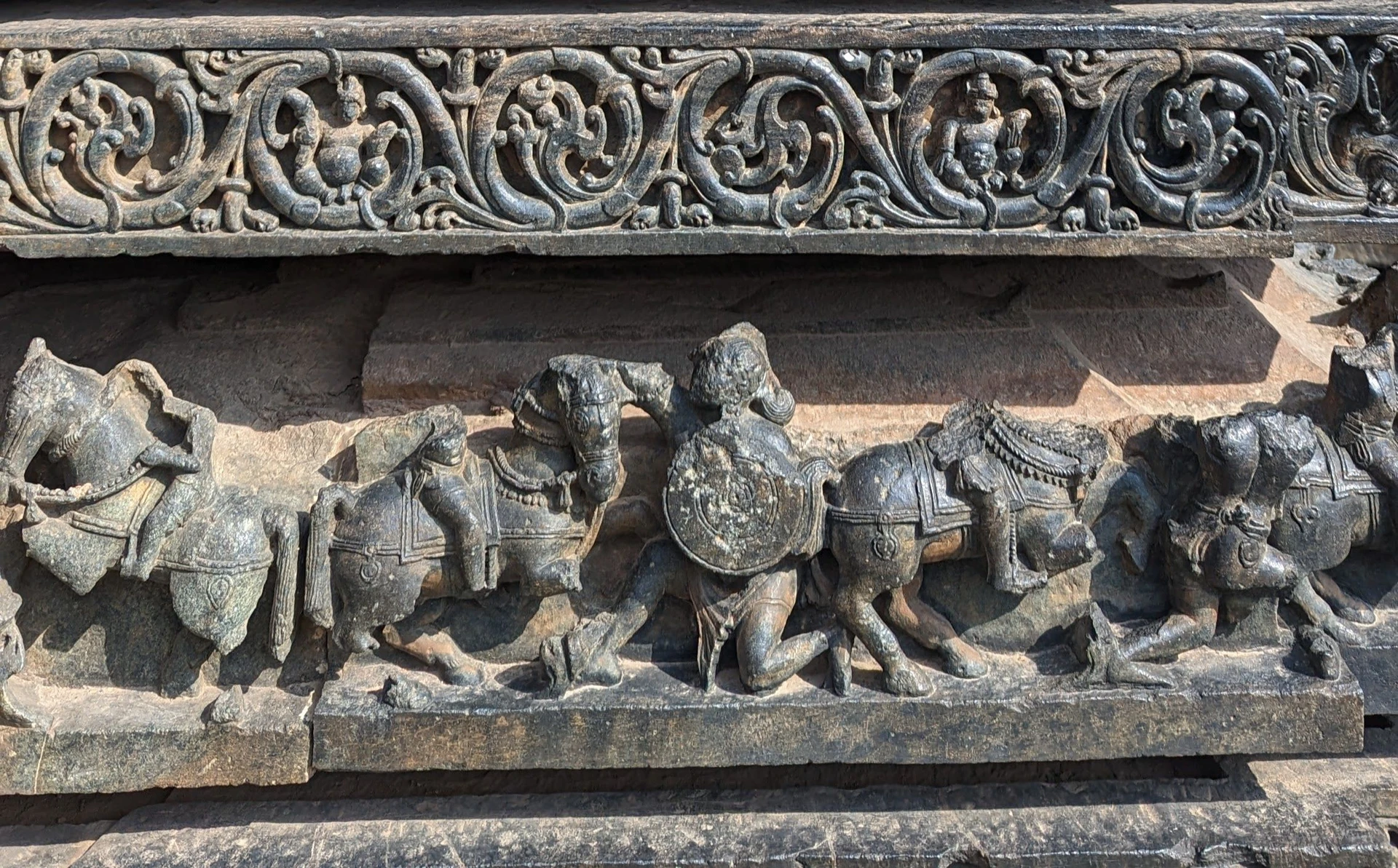 Cavalry frieze at Hoysaleswara Temple — galloping horses with infantryman bearing shield