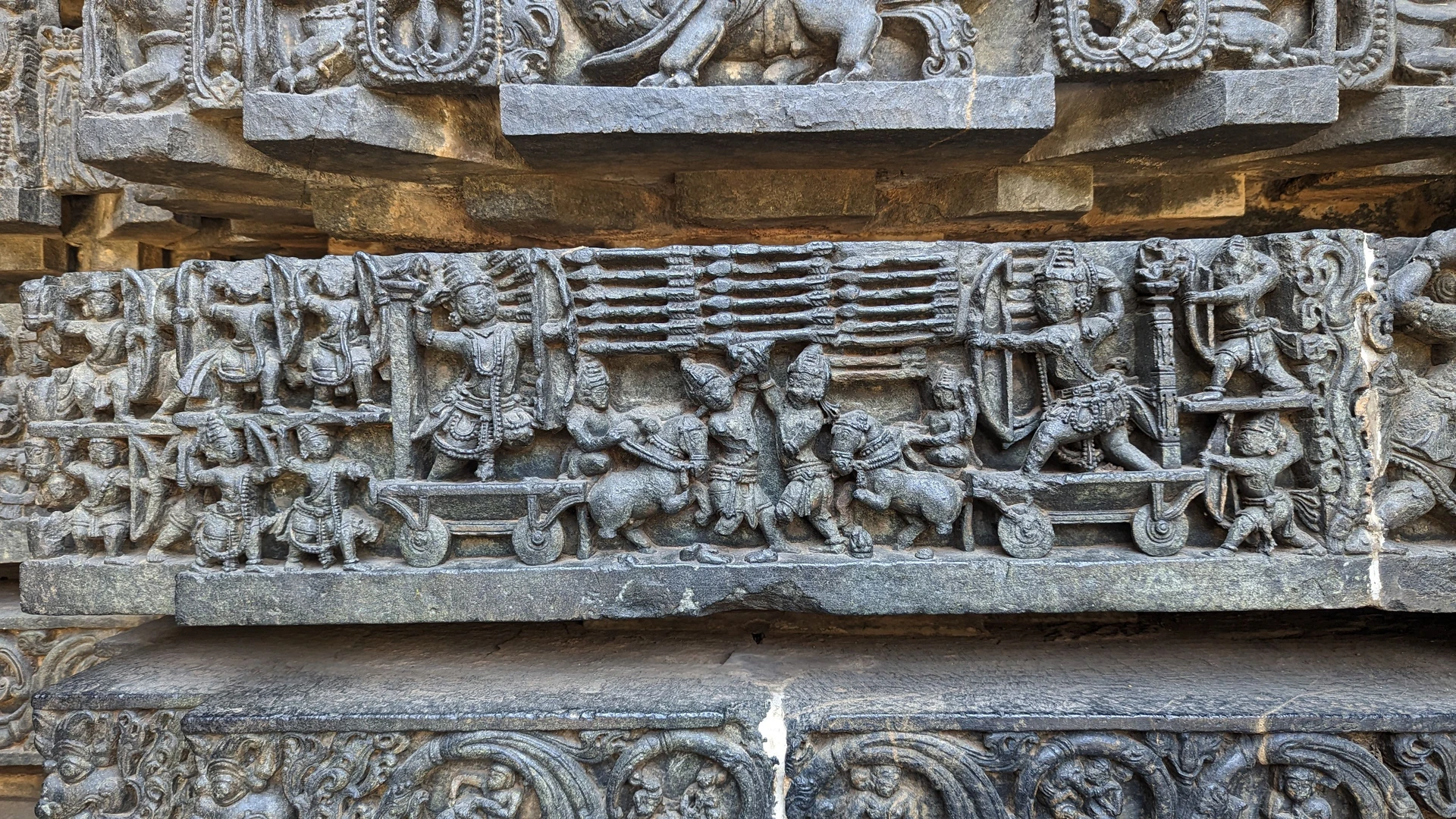 Battle of Kurukshetra — Arjuna versus Karna on opposing chariots, Hoysaleswara Temple frieze
